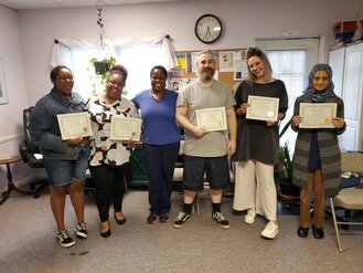 Reiki Master Teacher Kelly Nembhard with her students holding their Reiki class certificates
