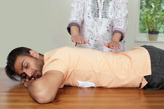 Practitioner performing Reiki healing on a client